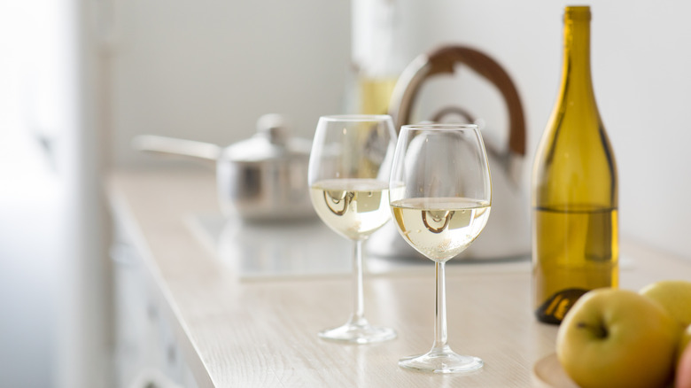 Two glasses of white wine on kitchen counter