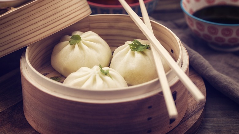 Steamed dumplings in a bamboo steamer with chopsticks