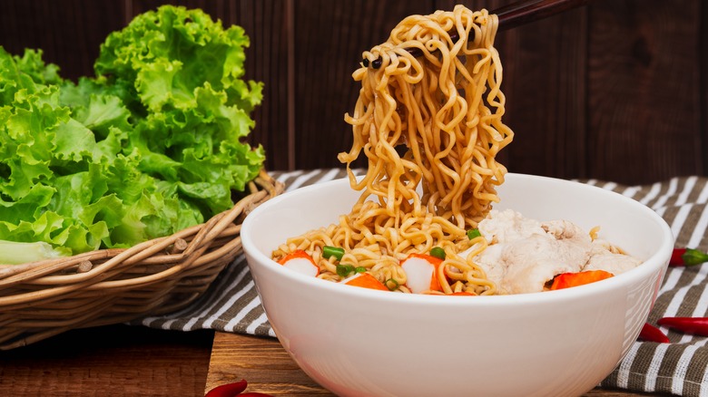 Chopsticks picking up ramen from a bowl