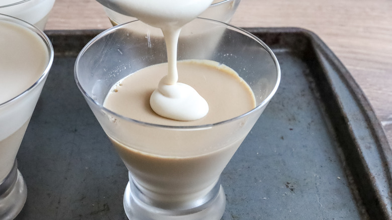 Irish cream layer being poured into glasses