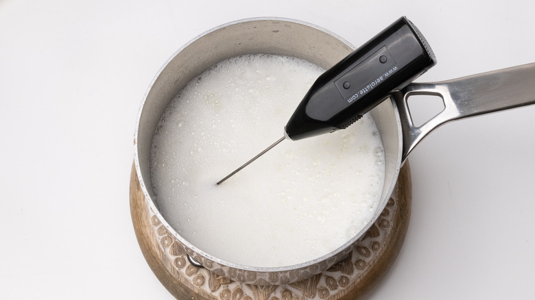 frothing milk in a saucepan