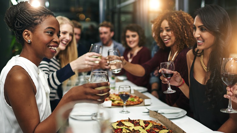 table of patrons toasting at a fine dining restaurant