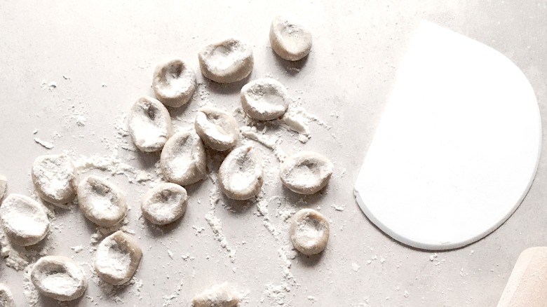 Dough on a light background and a bowl scraper