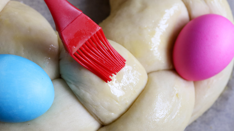 Egg wash being brushed onto braided loaf