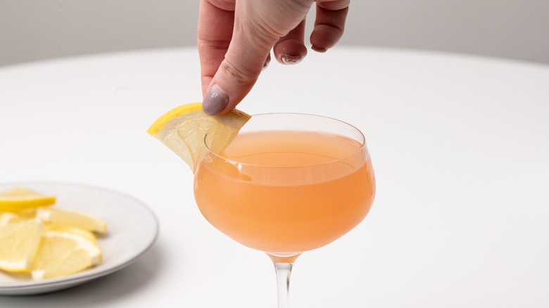 garnishing cocktail with grapefruit slice