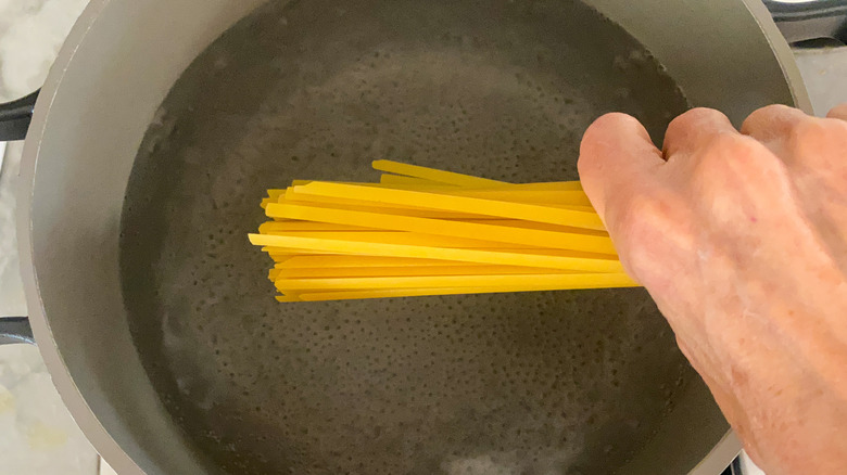 adding pasta to pot