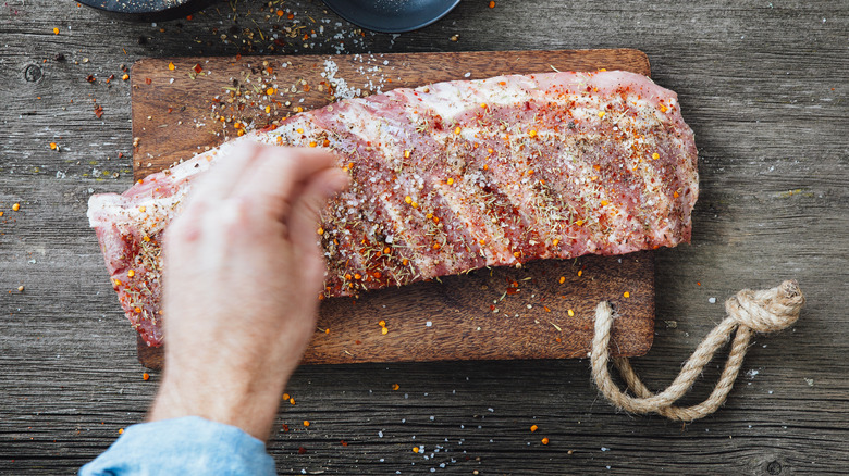 person seasoning steak