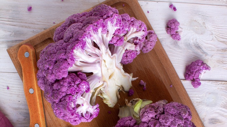 Chopping purple cauliflower on board
