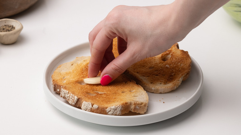 rubbing garlic clove on toast