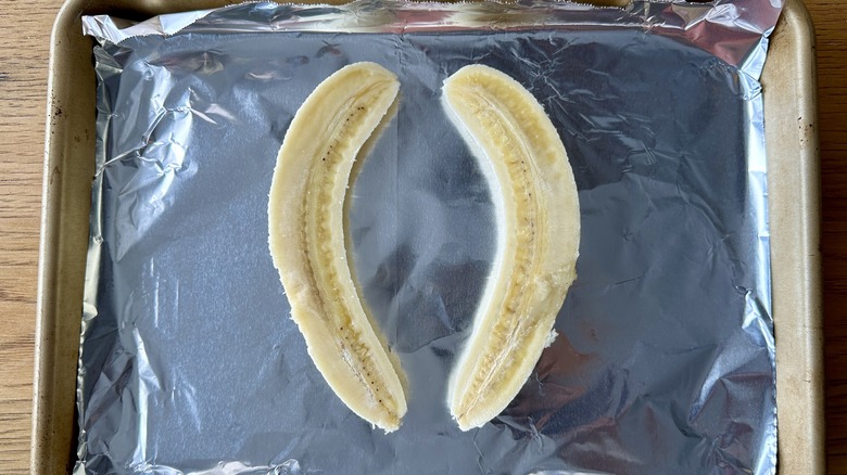 Halved bananas on baking sheet