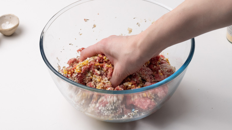 hand mixing meatball ingredients 