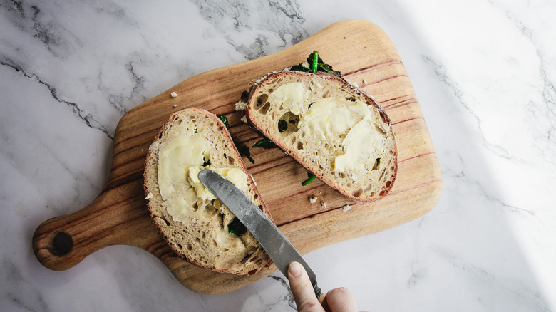 Spreading butter on grilled cheese