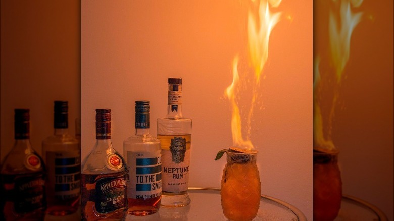 Flaming cocktail with liquor bottles