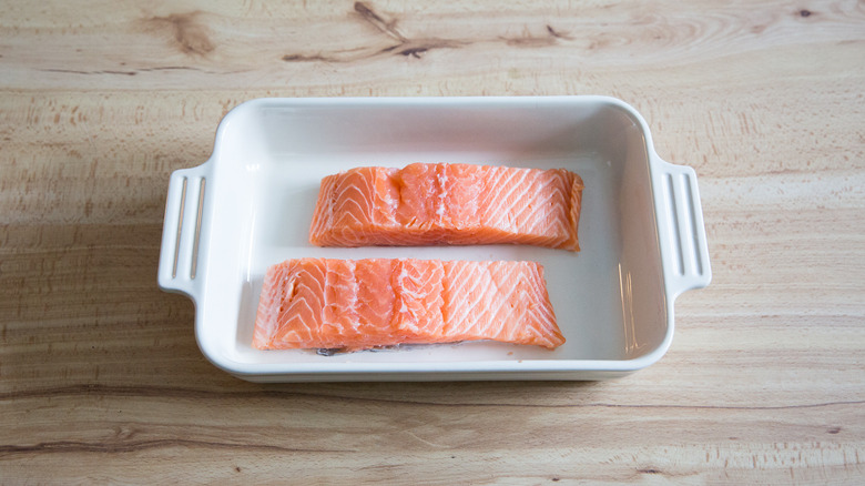 raw salmon fillets in pan