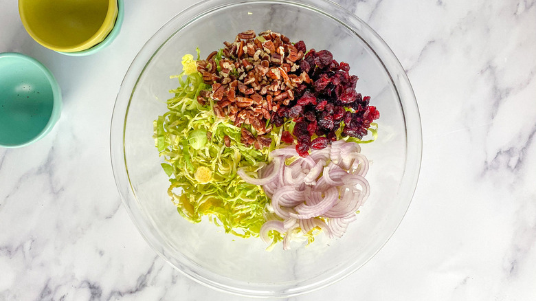 assembling Brussels sprouts slaw bowl