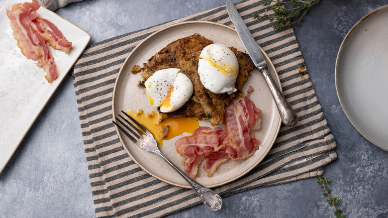 bubble and squeak with poached eggs and bacon on plate