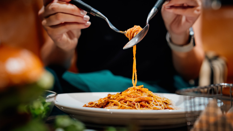 Foodie enjoying a plate of long pasta