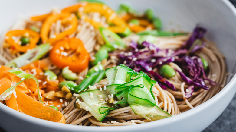 Bowl of noodles with chopsticks and toppings