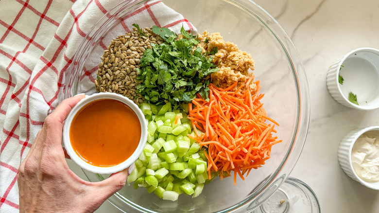 adding Buffalo sauce to bowl