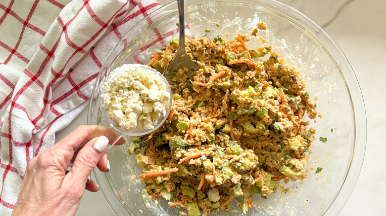 adding blue cheese to bowl