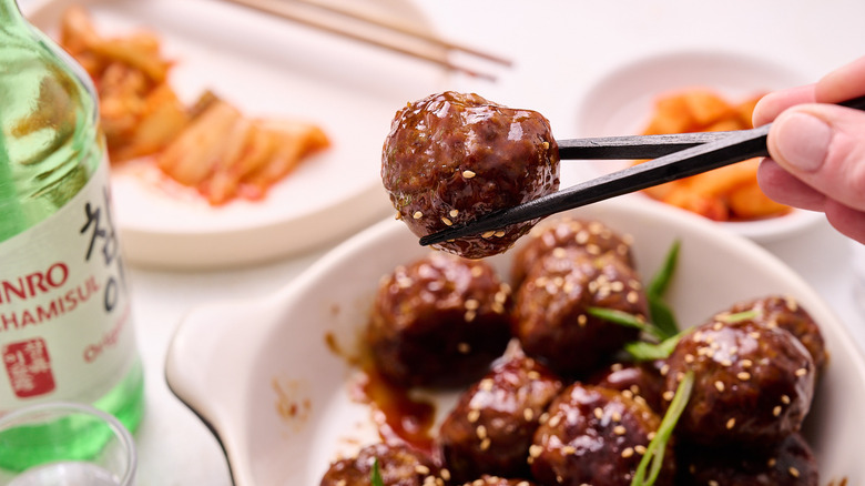 holding meatball between chopsticks