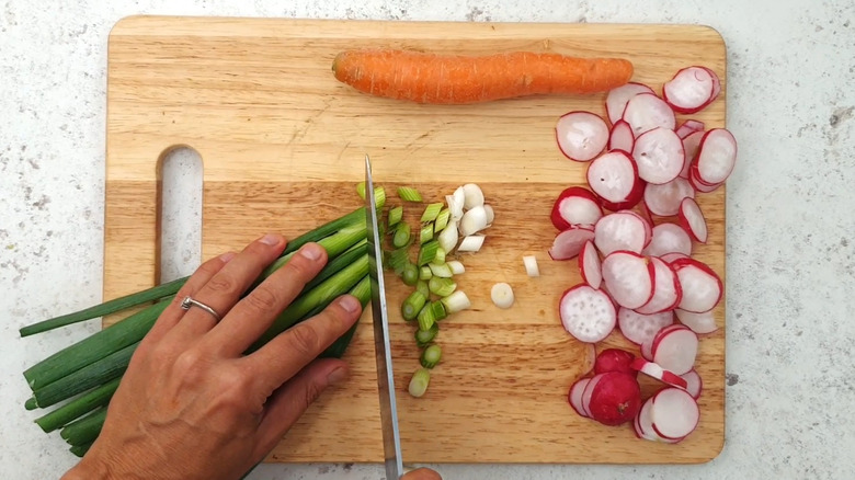 slicing scallions on cutting board