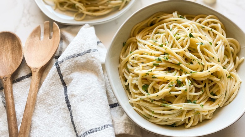 Overview of garlic butter noodles in a bowl with utensils