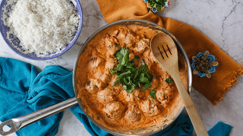 Kofta with rice and herbs in pan next to bowl of rice