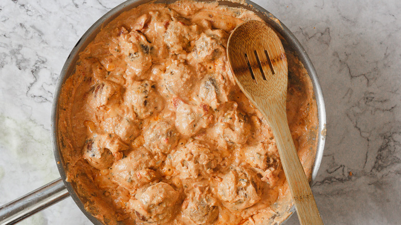 Kofta in light pink sauce with wooden spoon