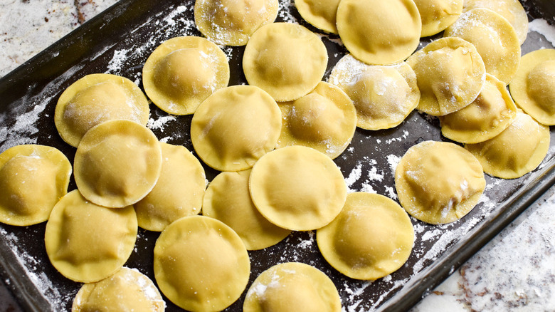 uncooked raviolis on baking sheet