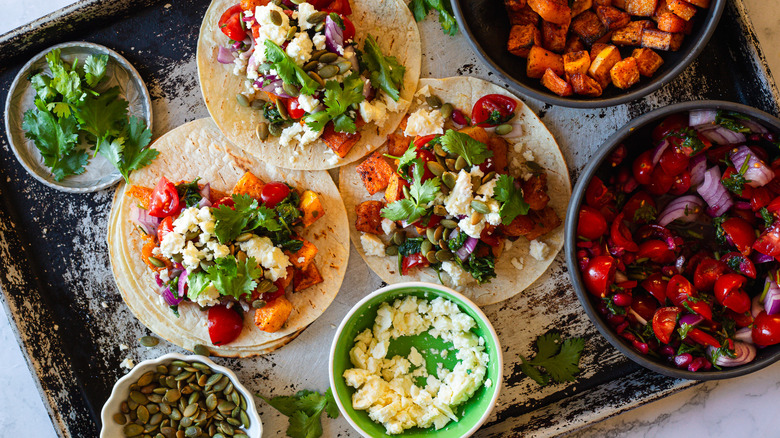 three tacos with all the components on baking sheet