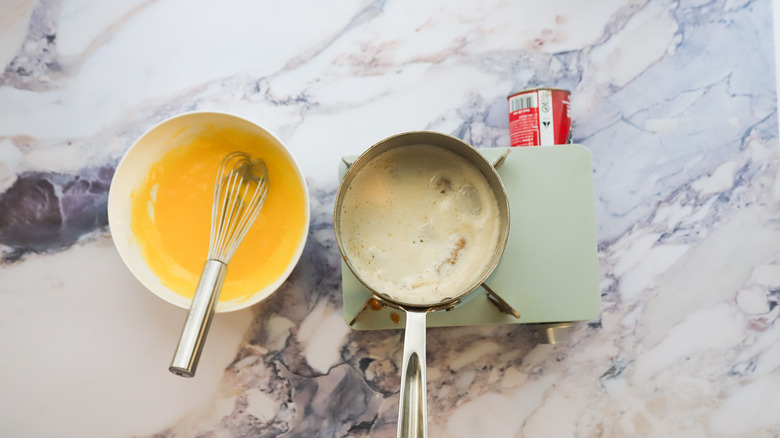 Whisked eggs next to pot