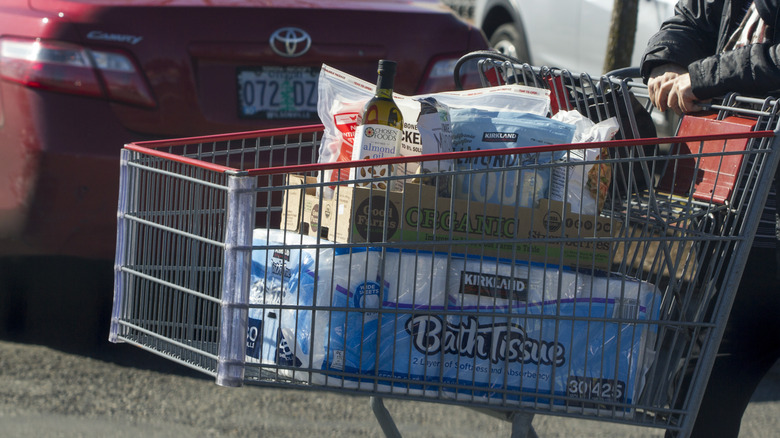 Shopping cart in Costco parking lot filled with bulk groceries