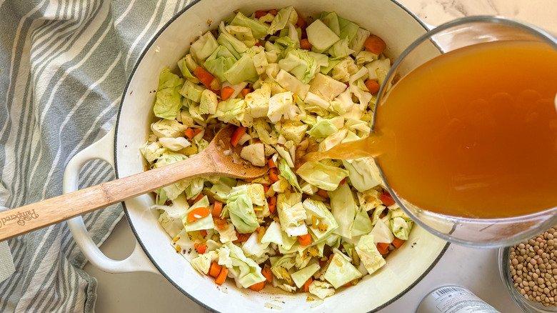 adding broth to pot