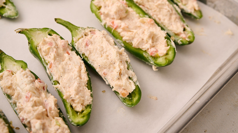 crab filled jalapeno on baking sheet