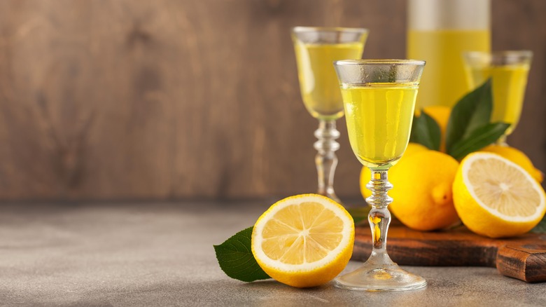 Two glasses of italian limoncello liqueur with halved lemons