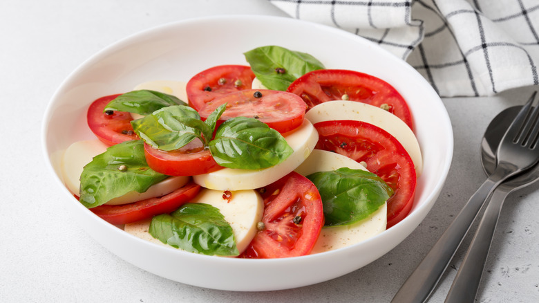 Caprese salad with fresh basil in bowl