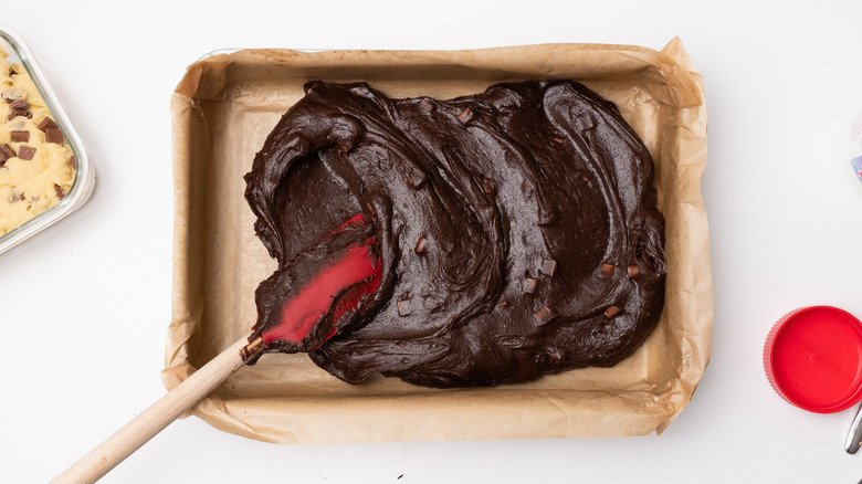 spreading brownie batter in tray