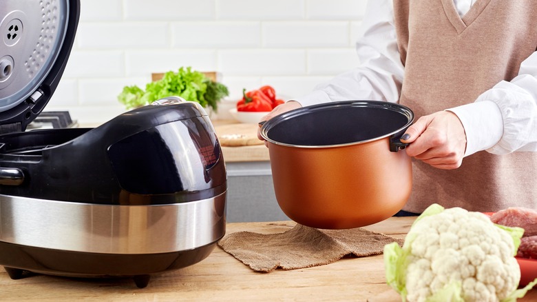 hands holding slow cooker pot