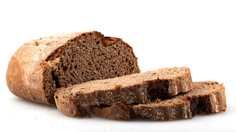 A loaf of brown bread and a few slices