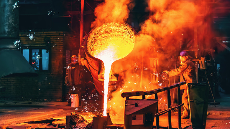 A worker pouring molten iron from a smelting ladle