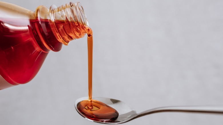 Pouring maple syrup from bottle to spoon