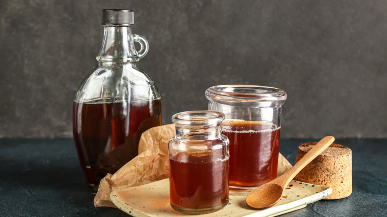 Jar and glasses of maple syrup