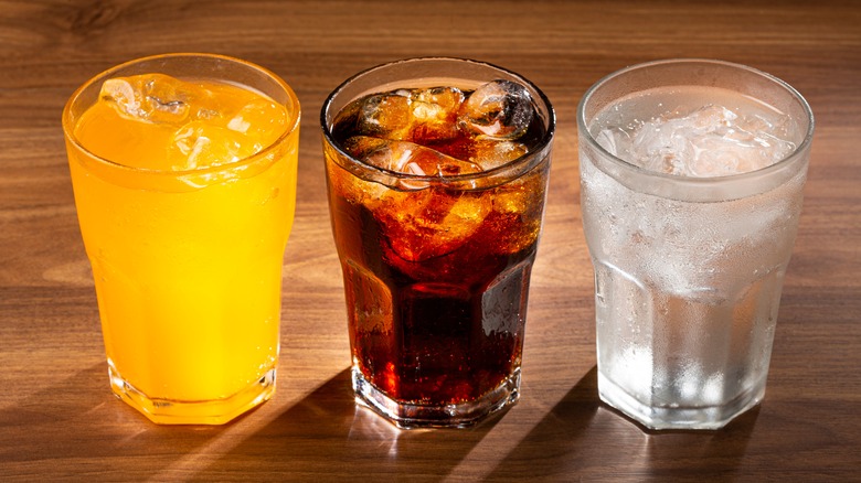 three glasses with different types of soda 