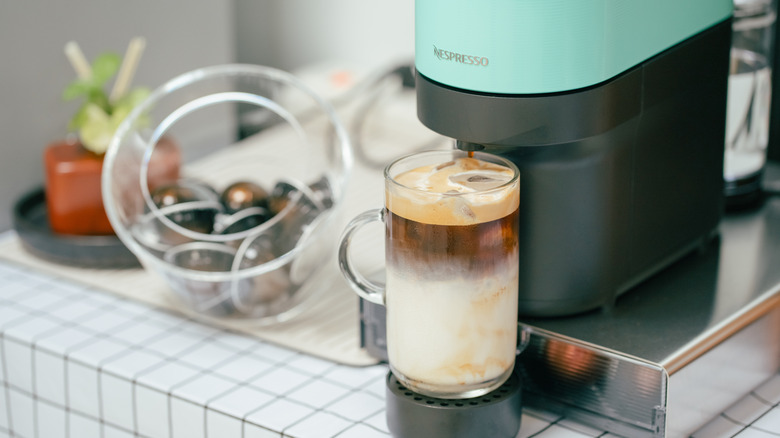 A Nespresso machine brews an iced latte