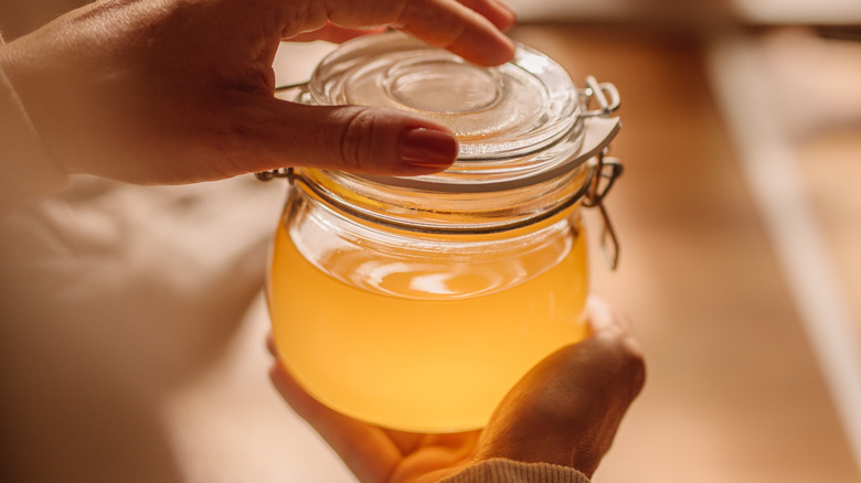 Hands holding jar of oil