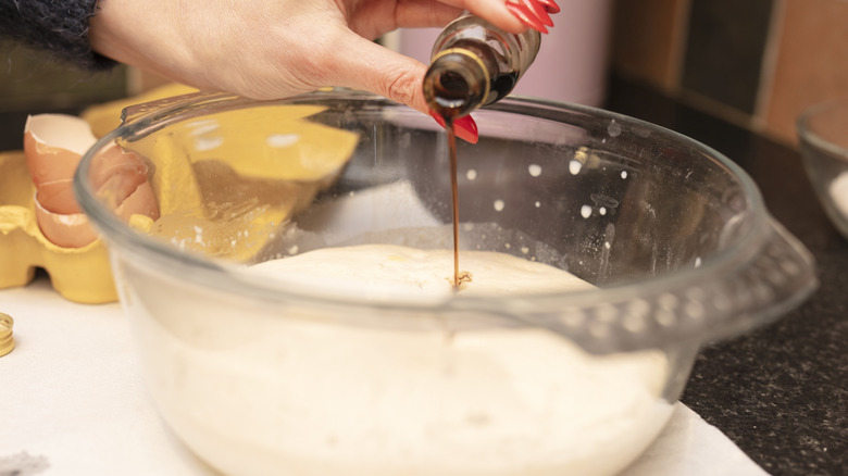 baker pouring vanilla extract