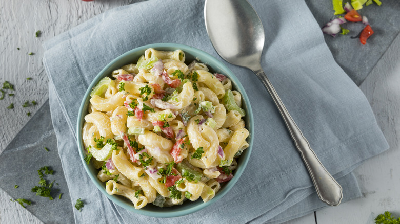 Macaroni salad and spoon on blue towel