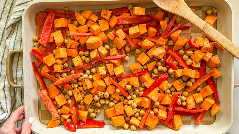 Chickpeas, red peppers, and sweet potatoes on baking sheet