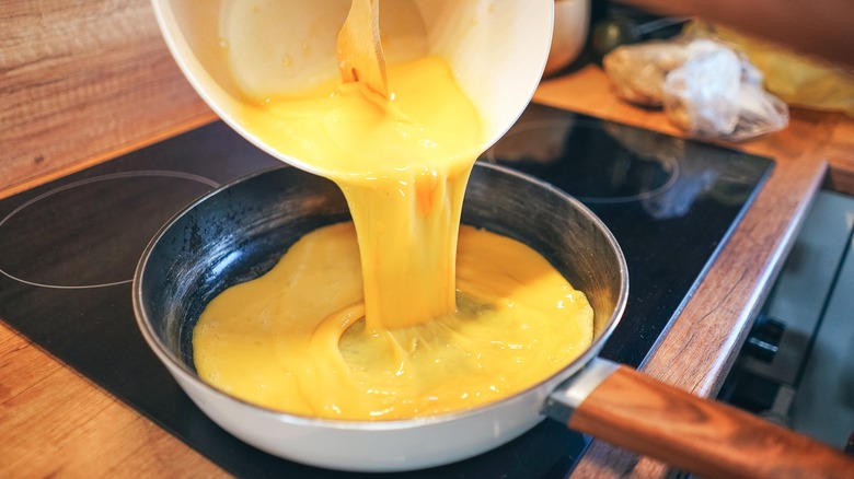 Pouring eggs into pan